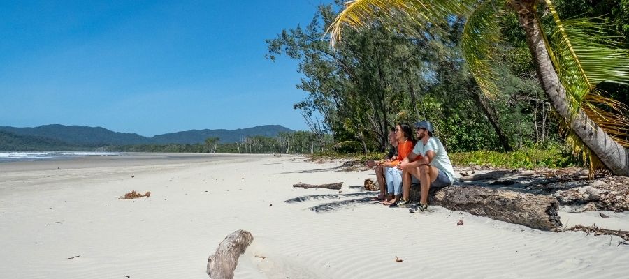 Friends sitting on beach overlooking Cape Tribulations beach